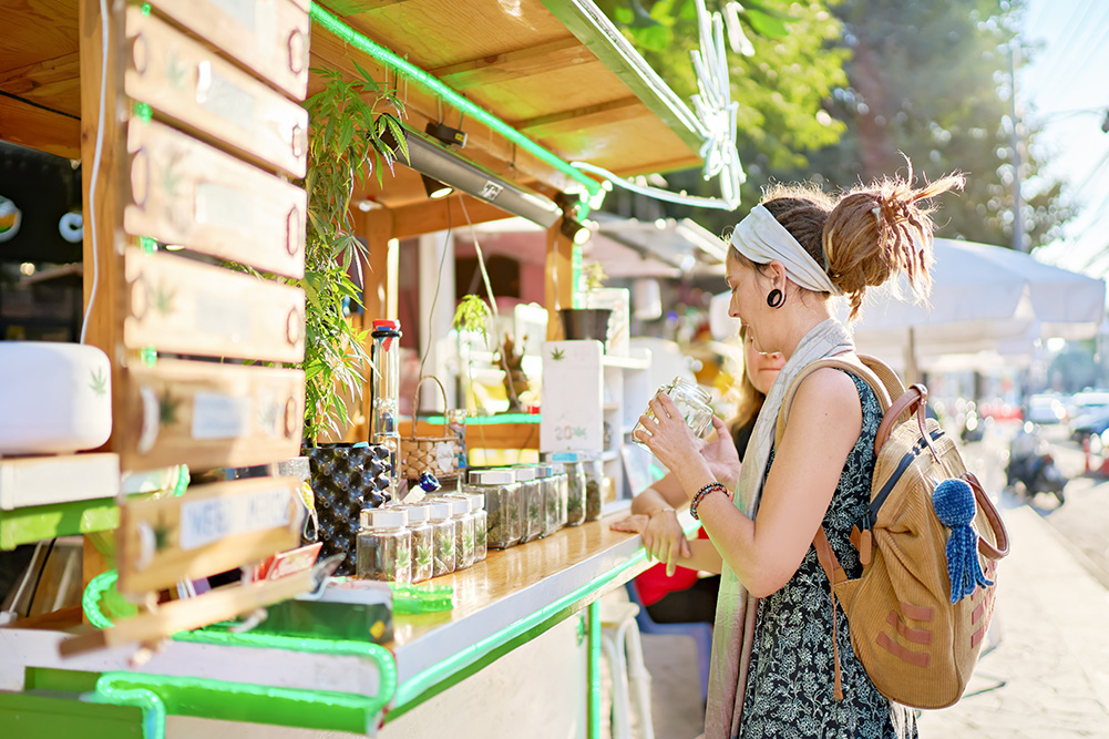 Lady buying cannabis at a stall